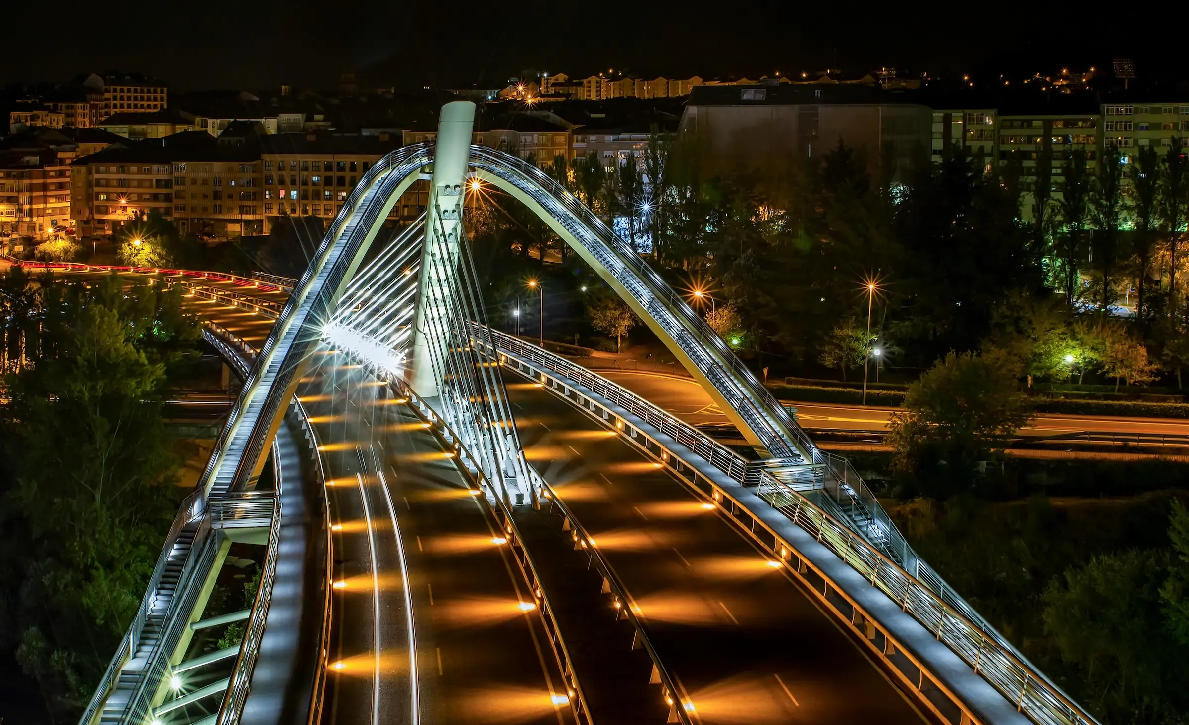 Vista nocturna do Ponte do Milenio de Ourense, iluminado, con estelas de luz do tráfico